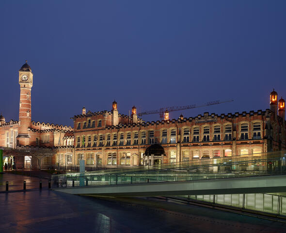 The illuminated façade and tower of Ghent-Saint-Pierre station at night