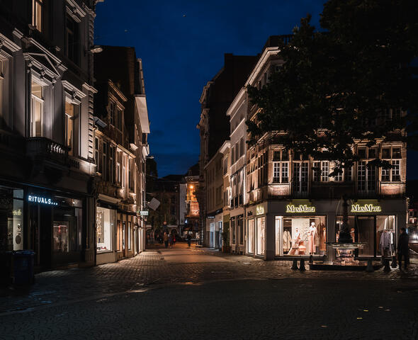 Verlichte etalages van de winkelpanden en verlichte fontein op de Kalandeberg in Gent