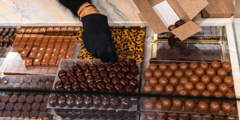 Une femme remplit une boîte de chocolats