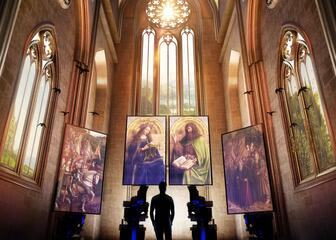 man die voor lights on van Eyck met 4 schilderijen staat