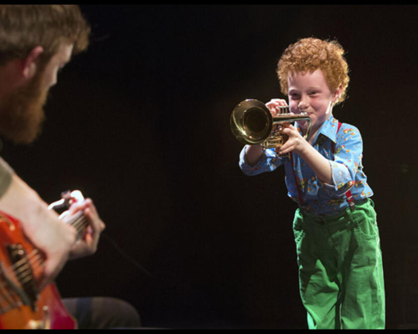 Kindje speelt op een trompet.