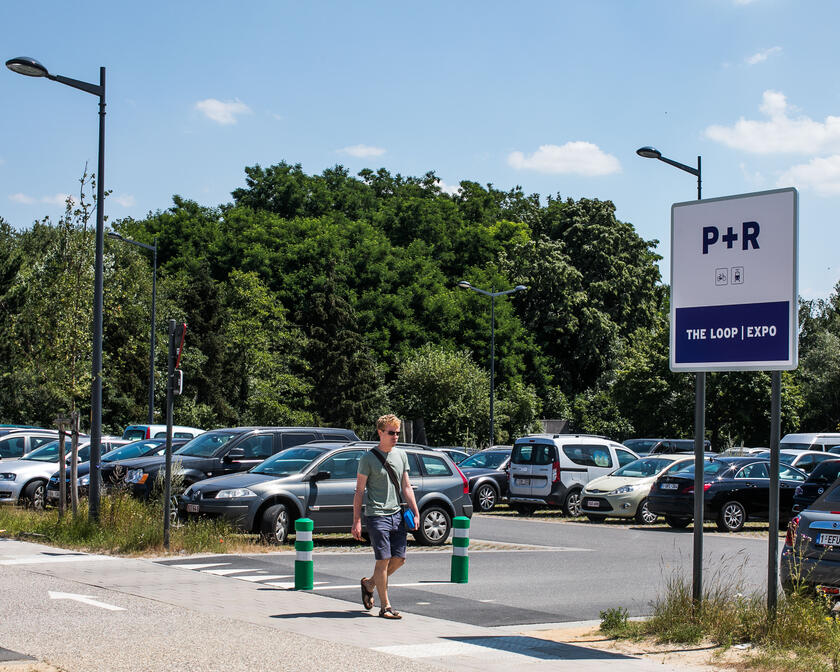 Young man walks past the entrance to the P+R at The Loop/Expo