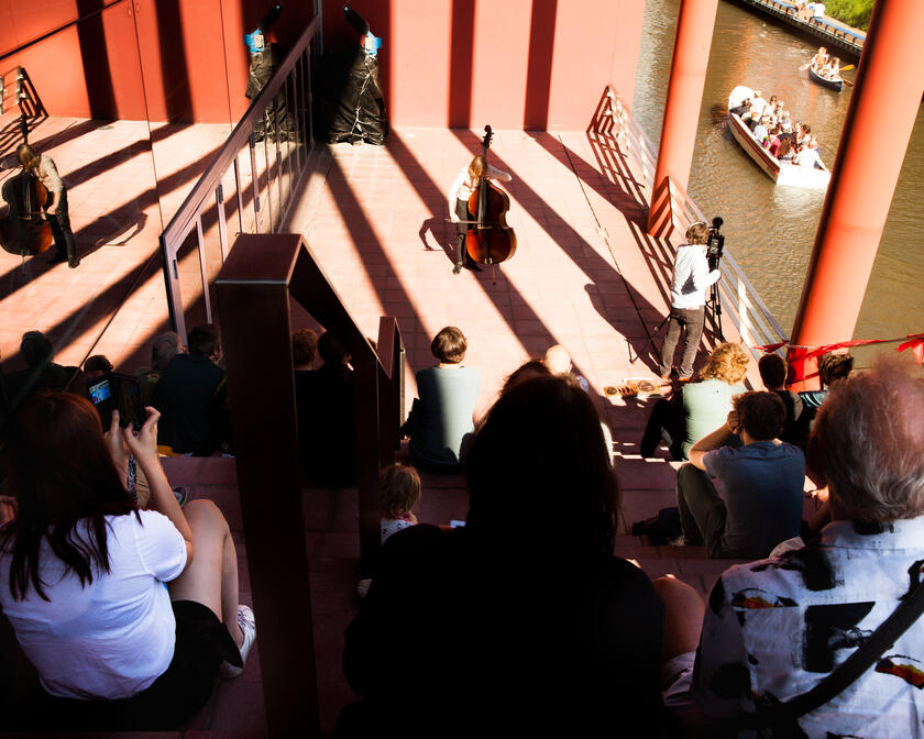 Bezoekers luisteren naar cellist in de Handelsbeurs