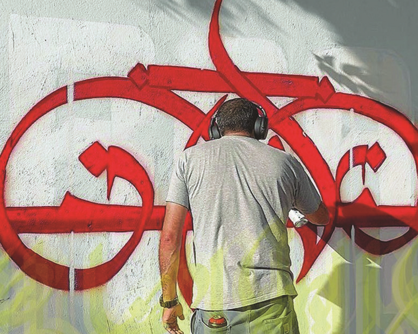 een man die rode graffiti op een muur aan het spuiten is en een koptelefoon draagt