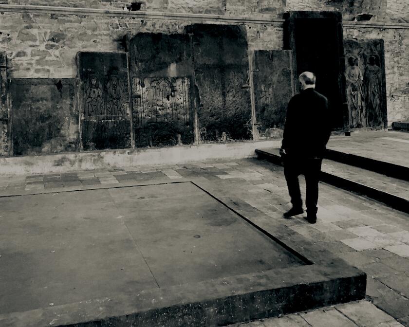 zwart-wit foto van man die naar kunstwerken kijkt