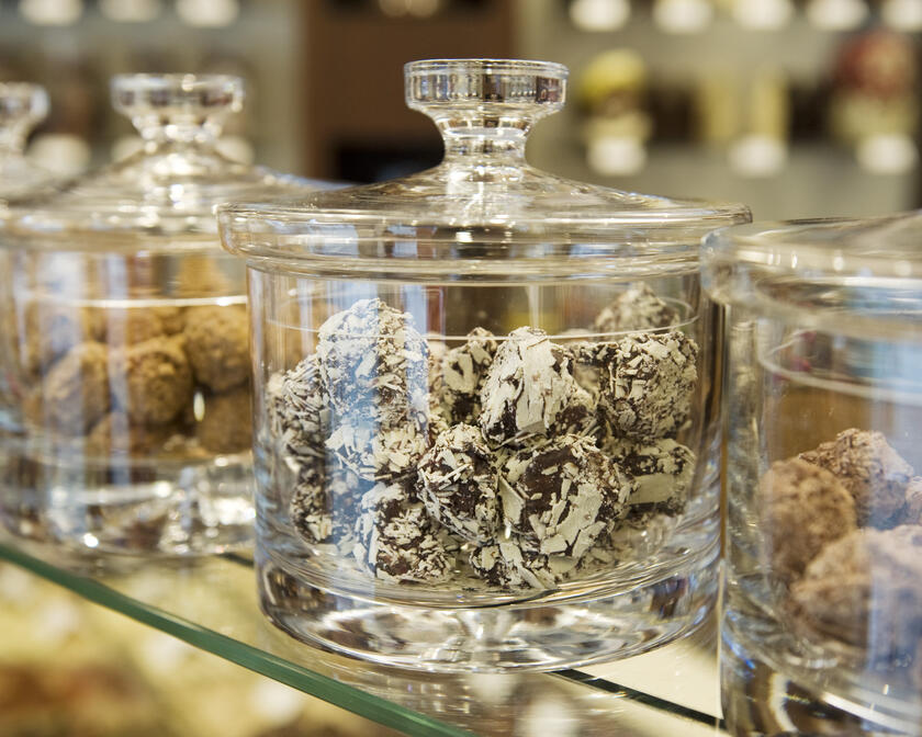 Close-up van verschillende soorten chocoladetruffels in glazen potten.