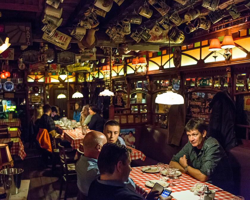 Volks restaurant voor 'ribbekes', met bierpullen aan het plafond, rood-wit geblokte tafellakens.