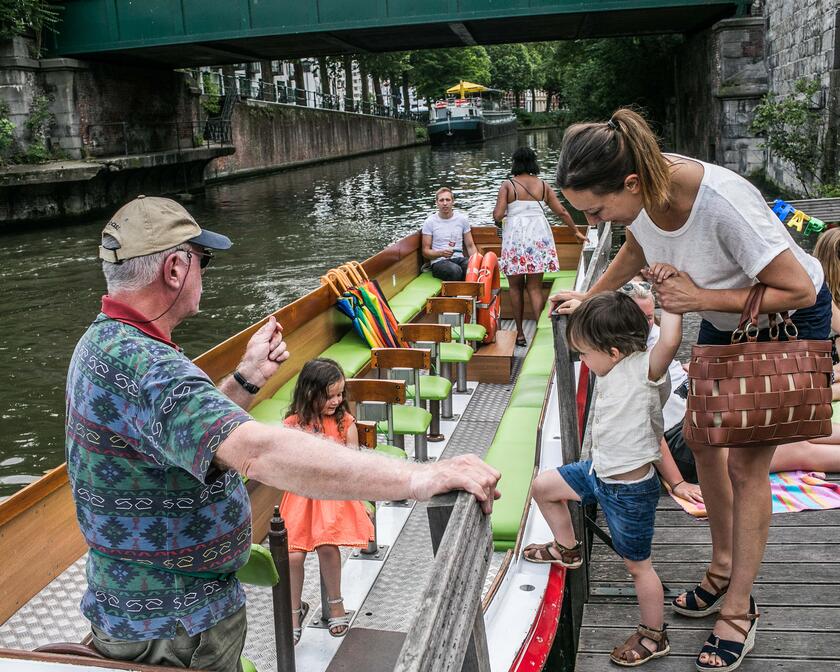 Een vrouw en haar kindje stappen op de watertram. 