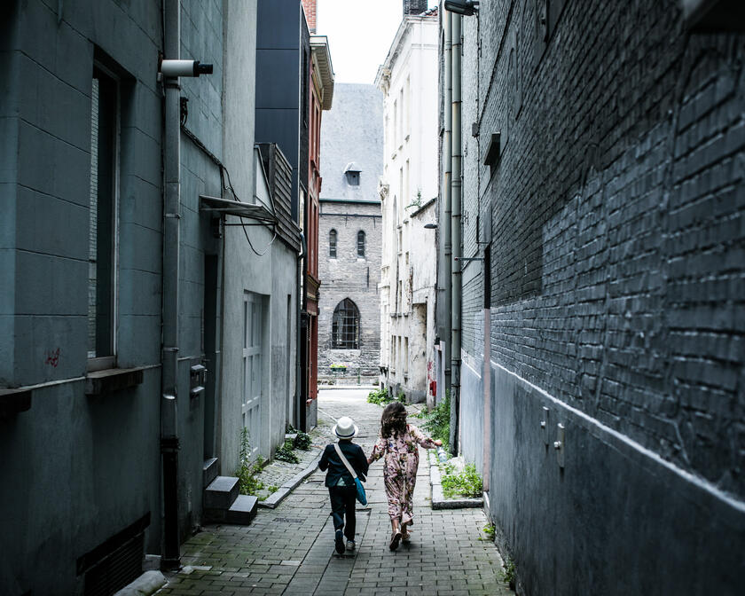 twee kinderen wandelen in een smal steegje