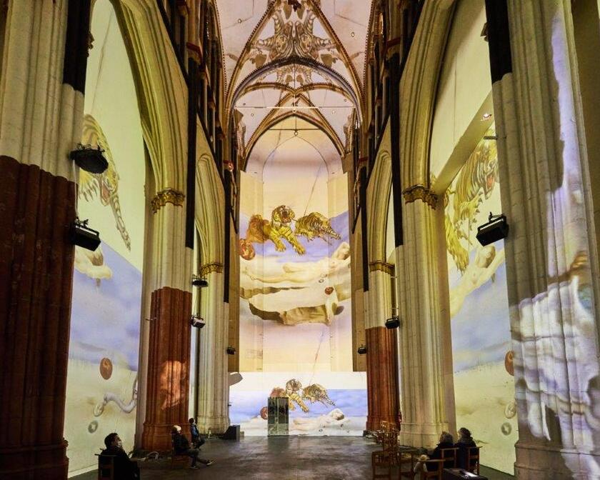 Spectacle de lumière coloré avec des œuvres d'art de Salvador Dali dans l'église Saint-Nicolas