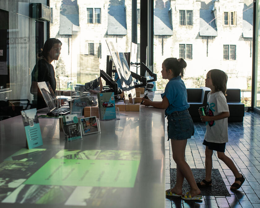 Deux enfants qui demandent des informations au bureau du tourisme de Gand