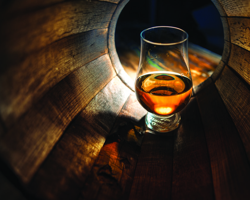 Glas mit Whisky in einem Faß
