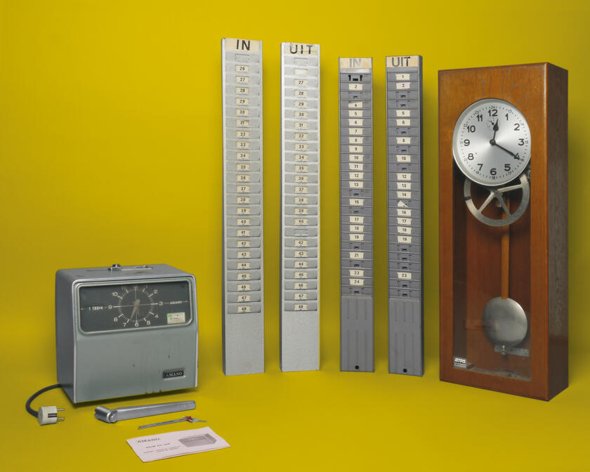 Prikklok van het merk Amano met metalen kaartenbakken en moederklok in houten kast. Afkomstig uit drukkerij Strobbe in Izegem, ca. 1950-1975.