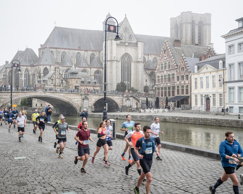 Marathoners op een mistige ochtend op de Graslei in Gent. ​