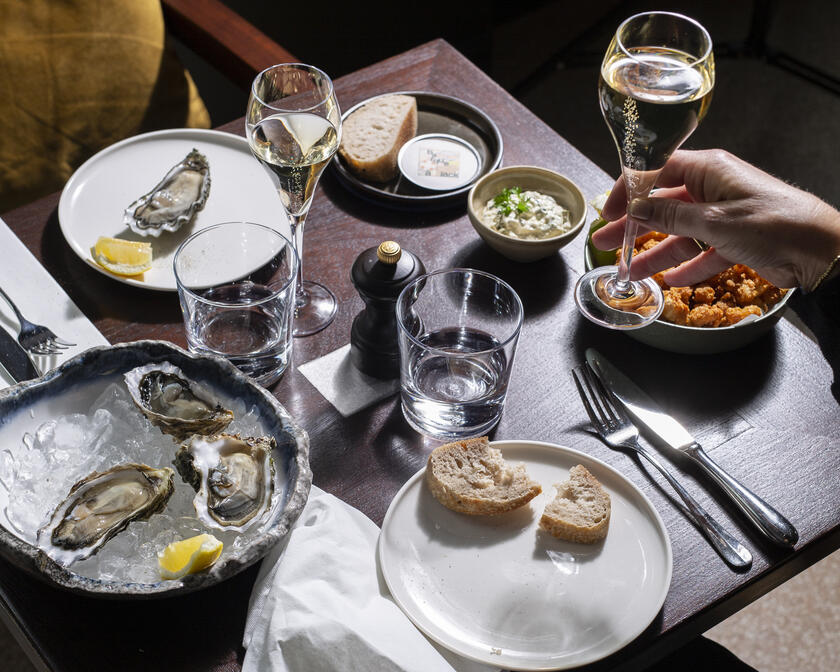 Tafel met witte borden met oesters en champagne