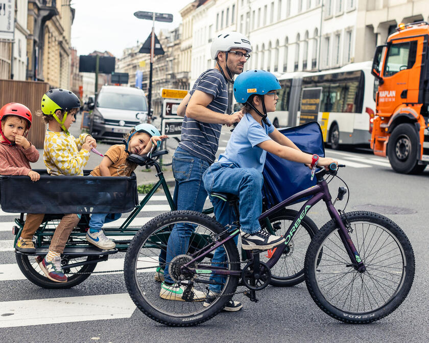 Father cycles with longtail bike with his family through the streets of Ghent