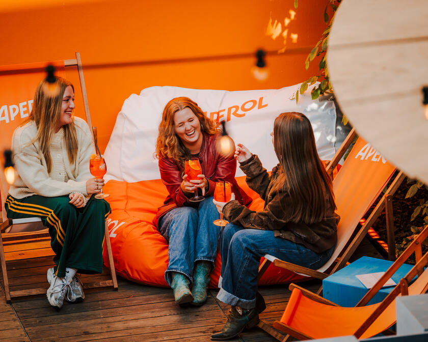 ©Bar Sauvage Three women sitting on beach chairs enjoying a drink