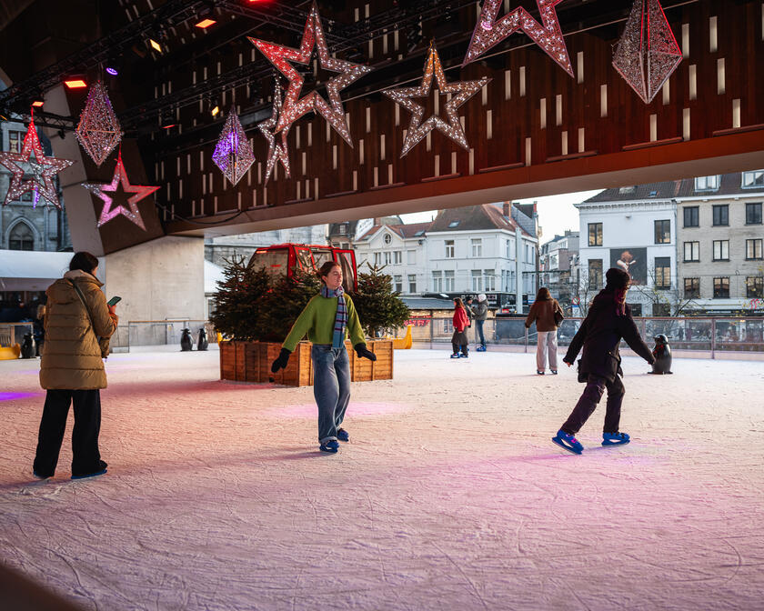 Mensen aan het ijsschaatsen in Gent onder de Stadshal