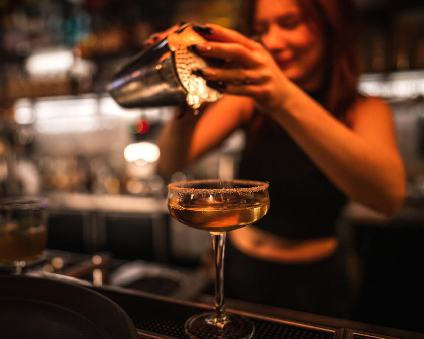 Barvrouw die een cocktail maakt