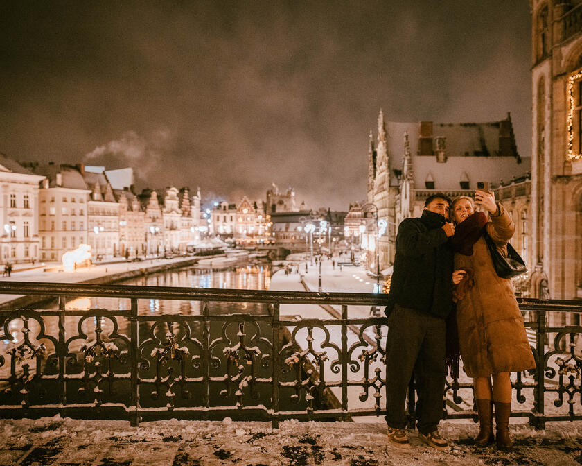 Twee mensen op de Sint-Michielsbrug die een selfie nemen in de sneeuw
