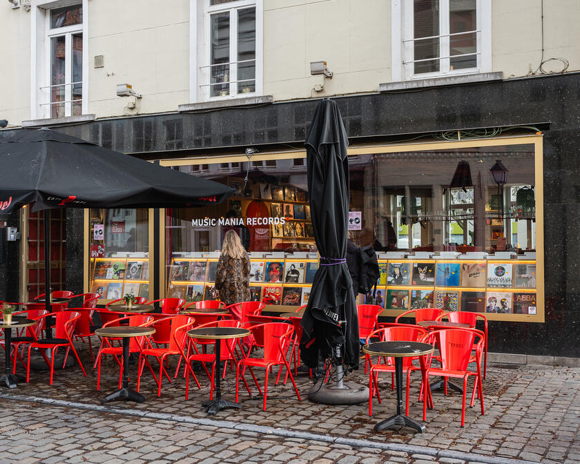 Terras met rode stoelen aan een platenwinkel