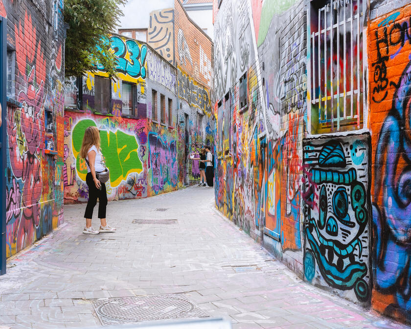 Vrouw aan het kijken naar de streetart in het graffitistraatje