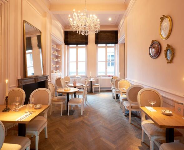 Wit interieur van Alice met porseleinen theepotten in de kasten.