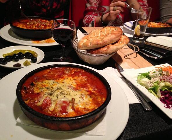 Rijkgevulde tafel met Turkse specialiteiten en gemengde sla.