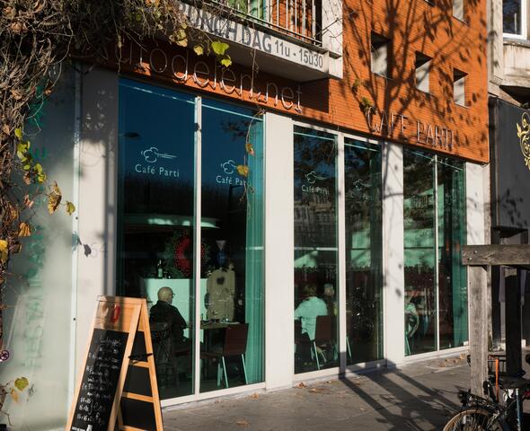 Buitenzicht van Café Parti, met grote raampartijen.