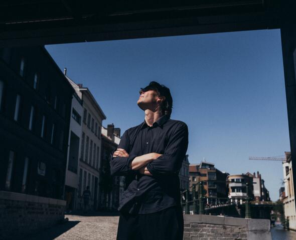 Wim Goens steht unter einem Gebäude, er blickt nach oben 