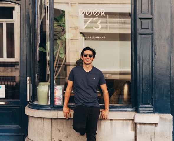 Marcelo Ballardin tegen de blauwe etalage van restaurant Door 73