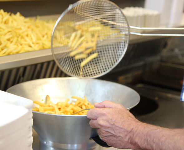 Voorbakken van frietjes, inox spaan en inox vergiet.