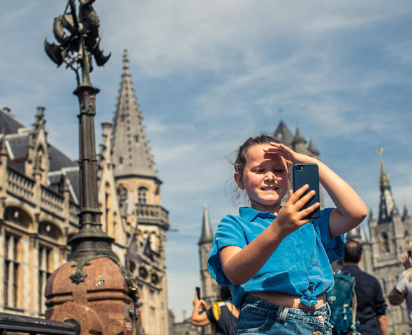 Meisje met smartphone op de Sint-Michielsbrug