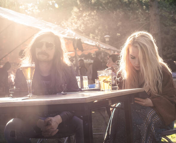 Dos personas en una mesa con una bebida