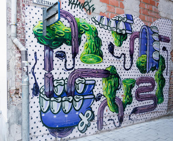 Murale colorée de HNRX dans une ruelle étroite