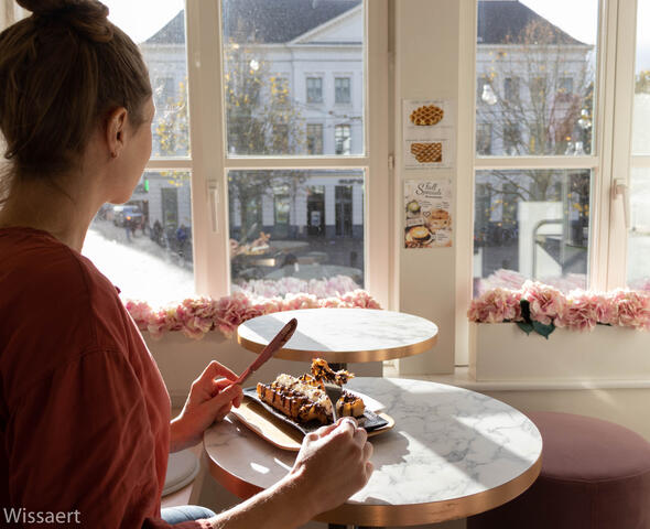 Una mujer come un gofre con vistas al Groentenmarkt