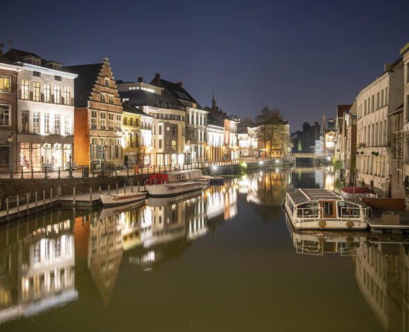 Verlichte huizen langs de waterkant aan de Kraanlei in Gent