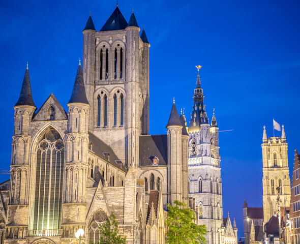 The three towers of Ghent, beautifully lit at dusk.