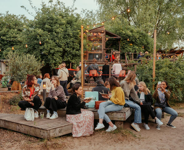 Eine Gruppe junger Leute genießt die Atmosphäre und ein frisches Getränk