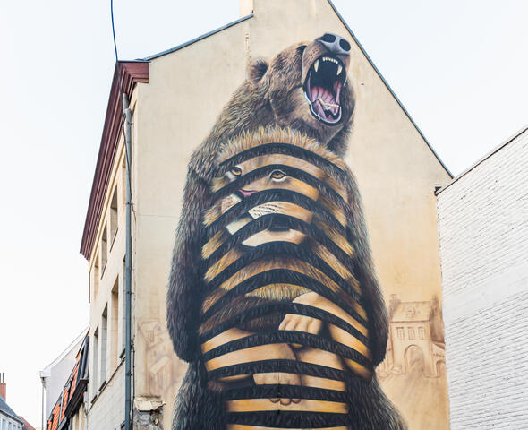 Muurschildering van een beer en een leeuw ineen