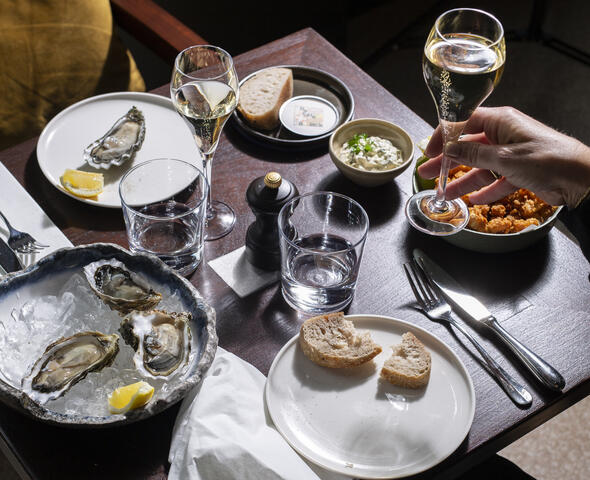Tafel met witte borden met oesters en champagne