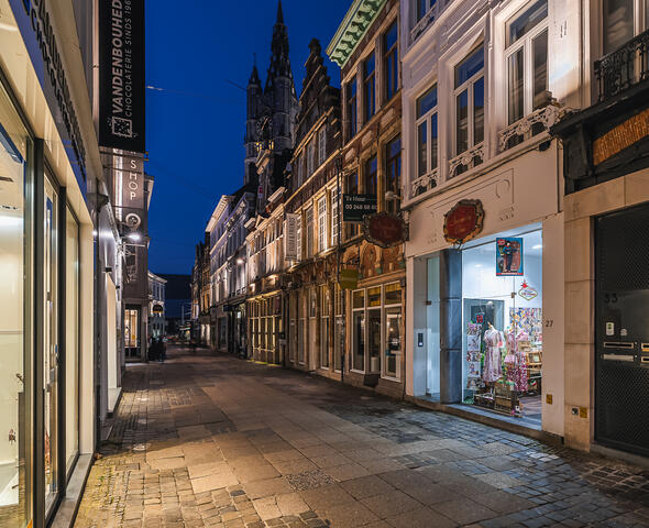 Verlichte gevels van de winkel- en handelspanden in de Mageleinestraat in Gent bij avond