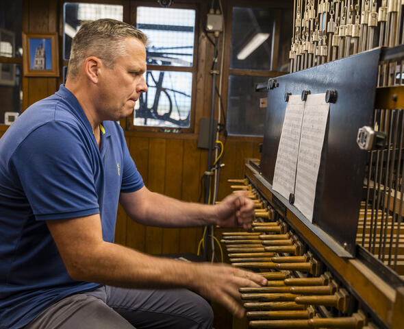 Carillonneur Ken Theunissen plays the keyboard consisting of sticks and pedals connected to the clappers in the bells