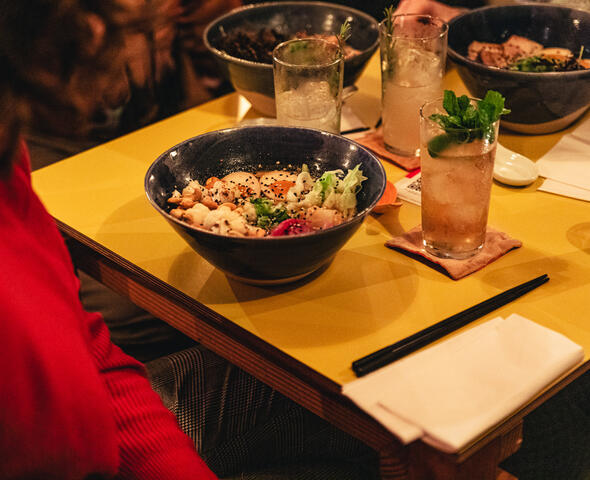 Een volle tafel met een dark & stormy cocktail en een vegetarische tantan ramen