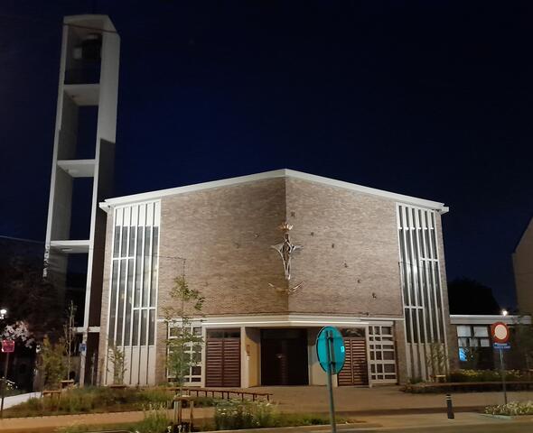Iglesia contemporánea iluminada con un campanario independiente de hormigón en Gante