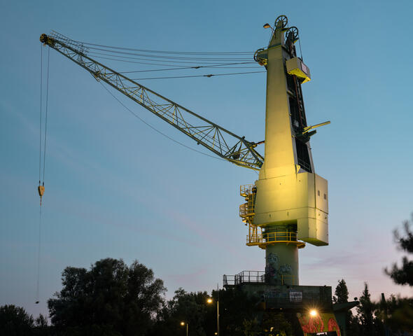 Grúa industrial verde ST1 iluminada al atardecer en Houtdok en Gante