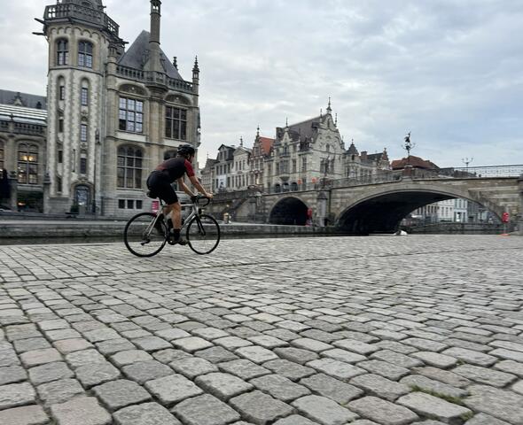 cyclist rides over the cobblestones at the Korenlei