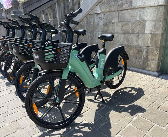 5 vélos Bolt garés au vert par une journée ensoleillée