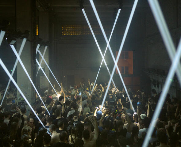 hondertal mensen staan te dansen in een club