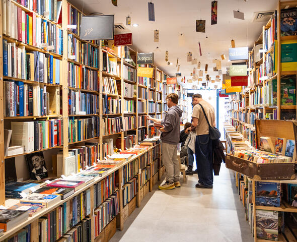 2 personen staan te kijken naar een kast vol boeken
